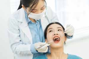 歯医者で定期検診を受ける女性