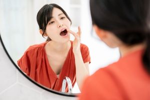 鏡で唇をチェックする女性