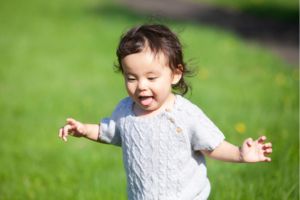 舌を出しながら歩き回る幼児